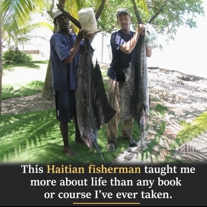 A Haitian fisherman and Kerry Reeves standing under palm trees on the shore, each holding up a sailfish caught that morning. The photograph is captioned "This Haitian fisherman taught me more about life than any book or course I've ever taken."